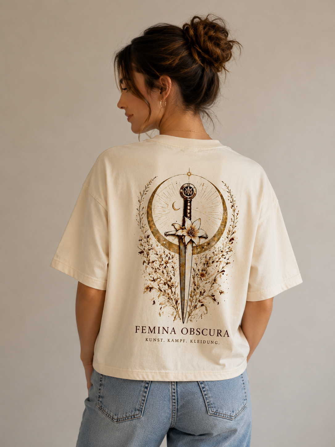 Getragen: Frau von hinten im cremefarbenen Silent-Power-Shirt – Rückenmotiv Dolch mit Lilie und Mondsichel, Schriftzug FEMINA OBSCURA